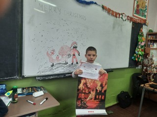 Ученикът от ОУ „Марин Дринов“ Калоян Грозданов с награта от  Международния конкурс за детска рисунка „С очите си видях бедата“